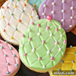 Easter Chocolate Push-Up Pops: Festive Treats for Kids 15 A pile of Fondant-Covered Easter Egg Cookies on a wooden surface.