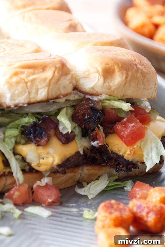 smashburger sliders assembled on a sheet pan with tater tots.