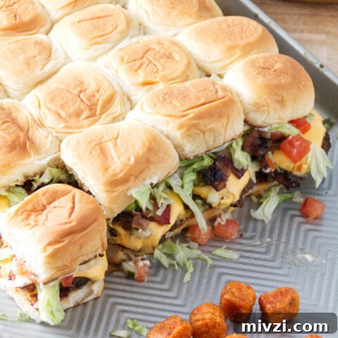 smashburger sliders assembled on a sheet pan with tater tots.