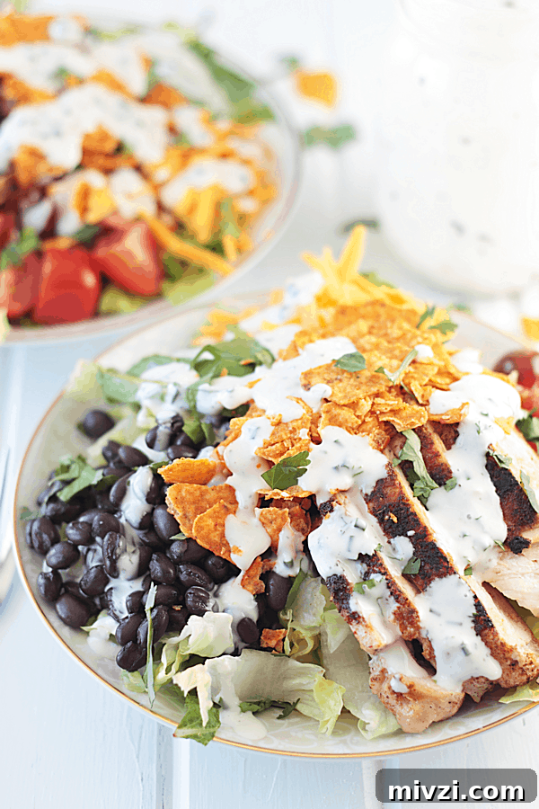 two bowls of taco salad topped with chicken and ranch