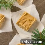 pieces of brown sugar fudge on pieces of parchment paper with fir branches