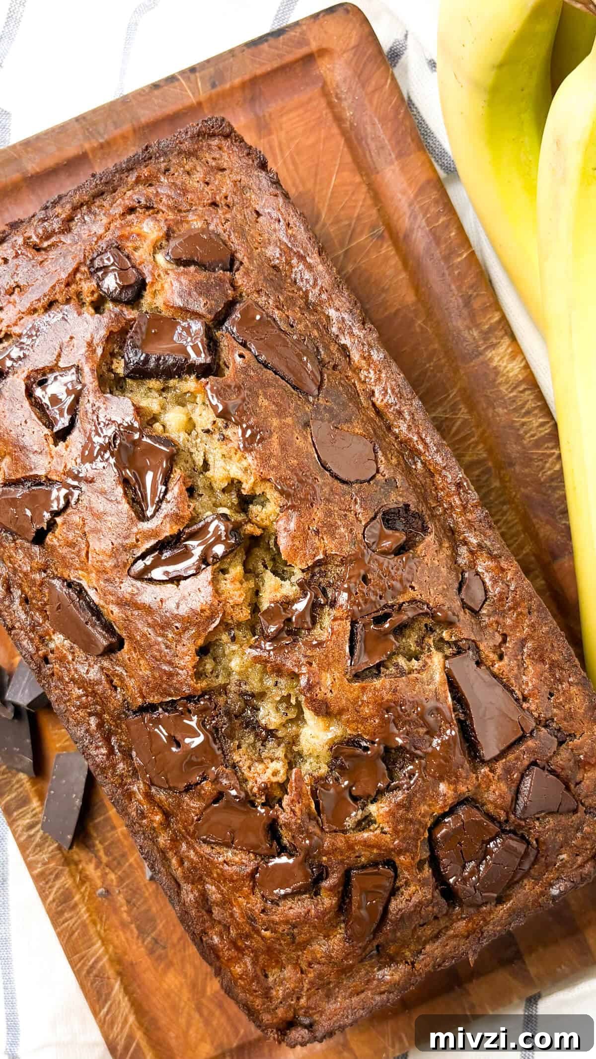 Chocolate Chunk Banana Bread Recipe with Gooey Chocolate Chunks 10 Finished bread on cutting board.