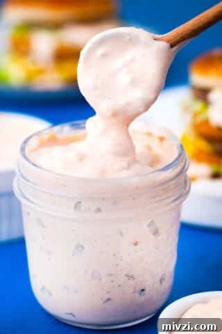 homemade thousand island dressing dripping of a spoon into a jar