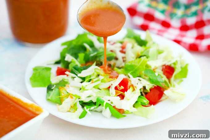 Homemade Catalina Salad Dressing in 5 Minutes 3 Drizzling Catalina dressing over a green salad.