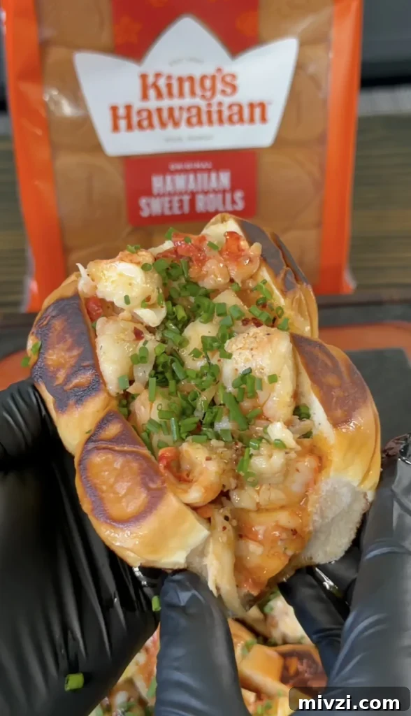 Spicy Hot Honey Lobster Rolls with Chili Crisp 5 Hot honey butter lobster roll in toasted brioche bun topped with fresh chives and diced tomatoes