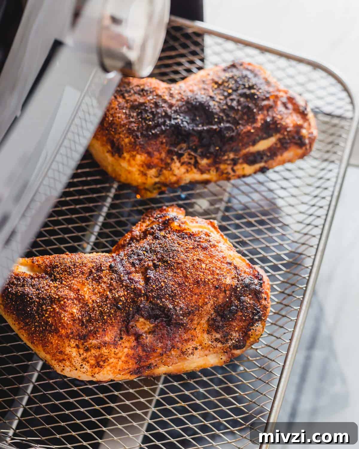 Air fried chicken leg quarters on the tray in an air fryer. Air fried chicken leg quarters on the tray in an air fryer.