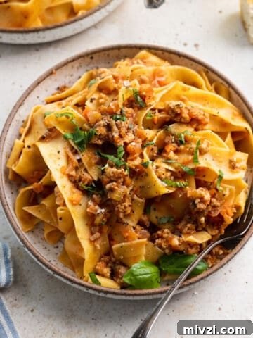 Chicken bolognese in a bowl with a fork.