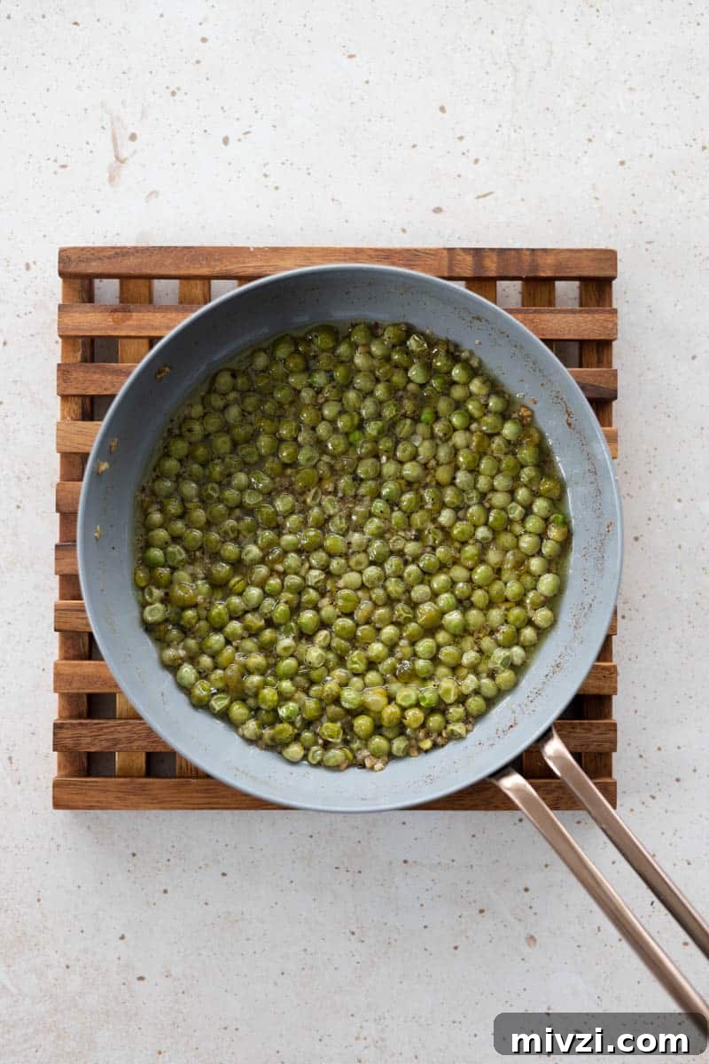 Cooked peas and olive oil in a small skillet.
