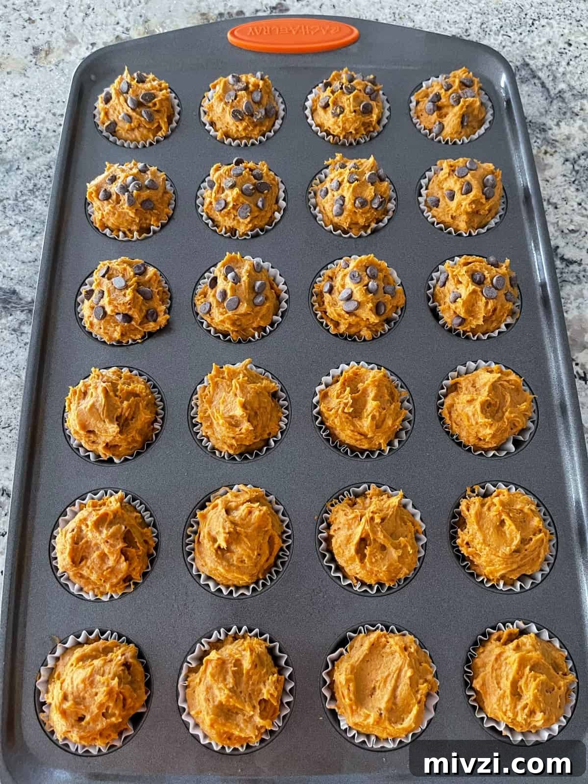 Pumpkin Spice Muffins Made from Cake Mix (Weight Watchers-Friendly) 6 Mini muffin tin with unbaked pumpkin spice cake mix muffins - half plain and half topped with miniature chocolate chips.