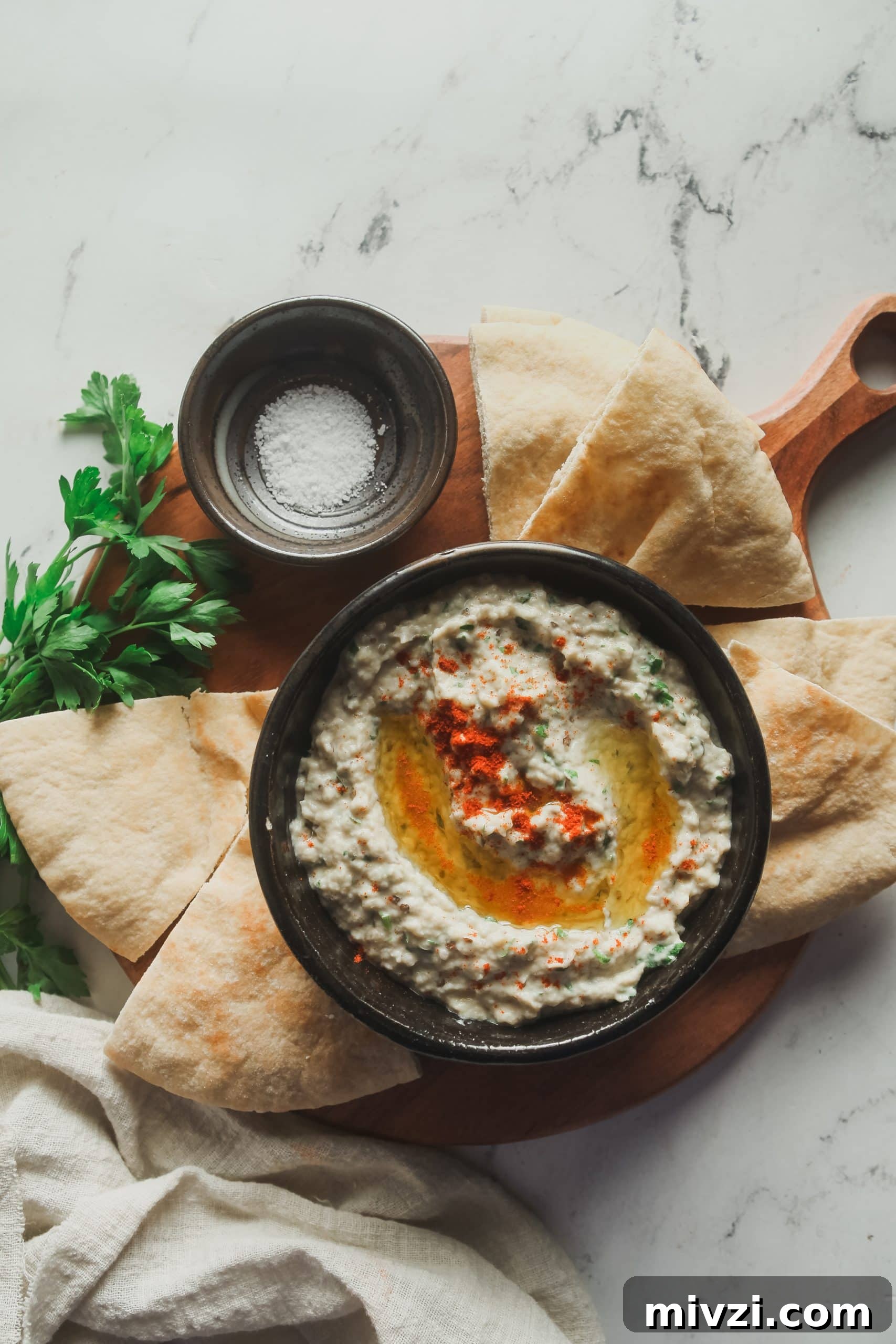 Overhead view of baba ganoush with smoked paprika and pita wedges.