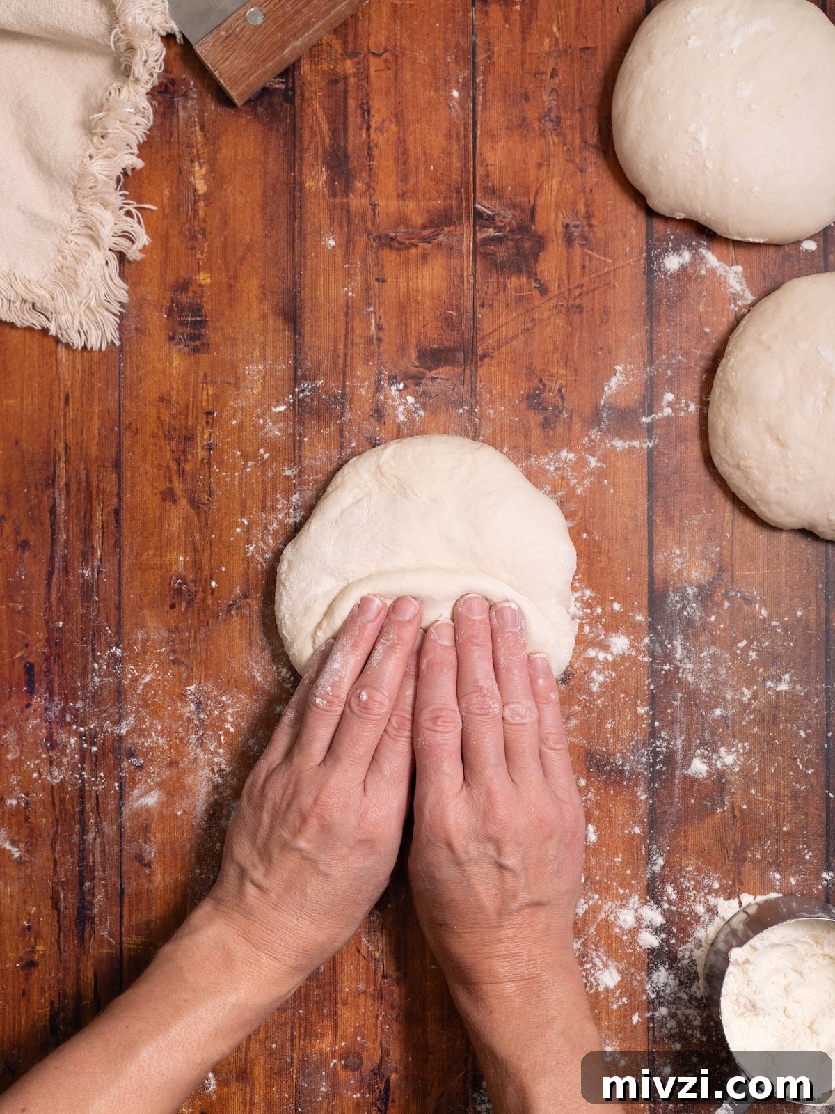 How to Make Classic Sourdough Baguettes at Home 6 Folding sourdough baguette dough in half