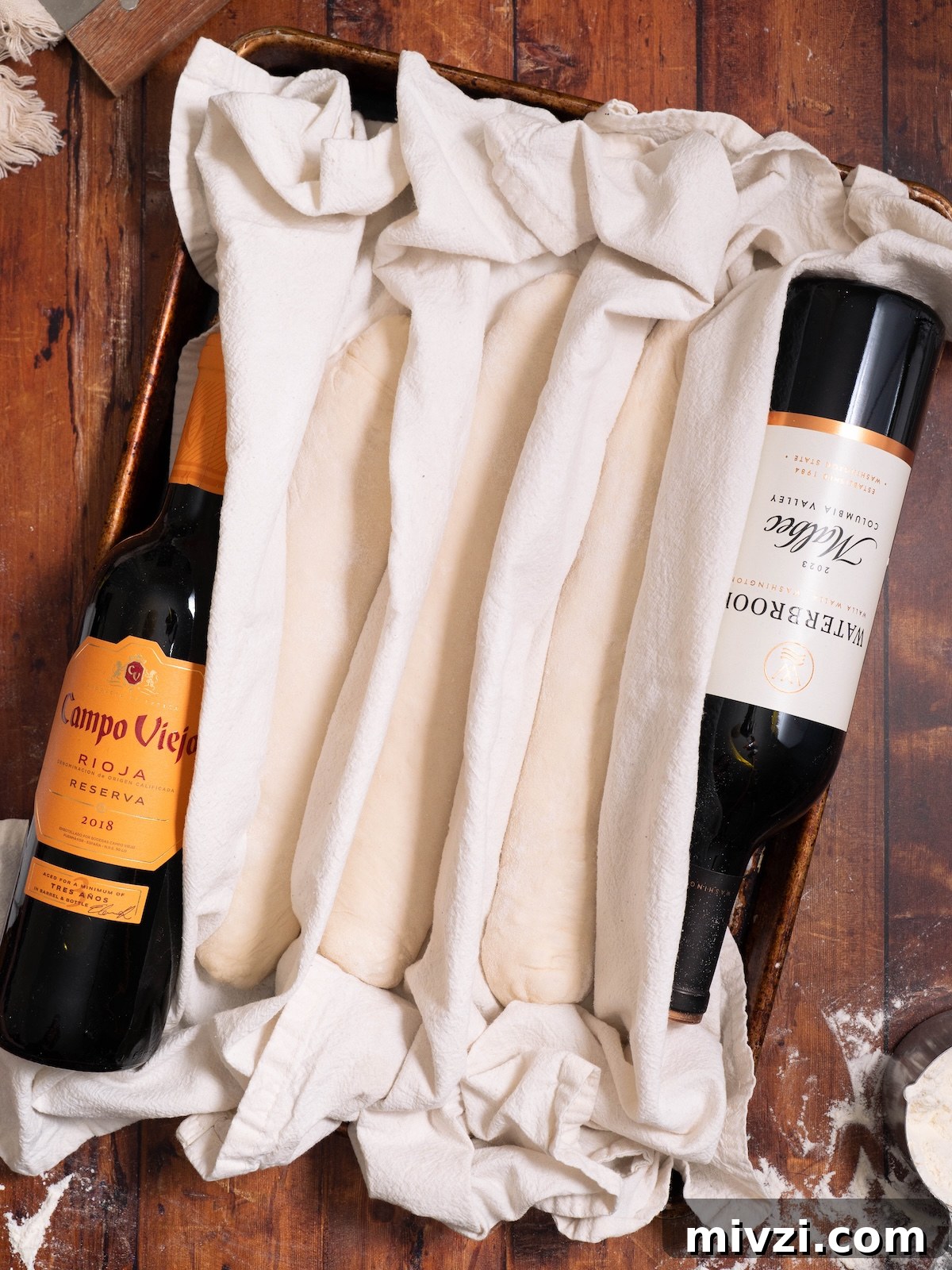 How to Make Classic Sourdough Baguettes at Home 10 Baguettes proofing between layers of floured tea towels
