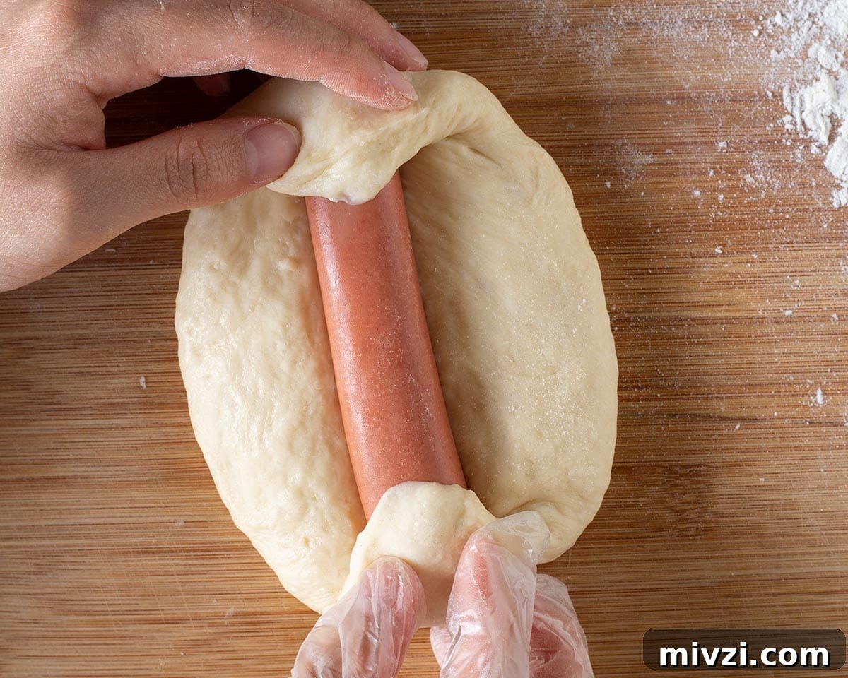 Wrapping the hotdog into the dough.