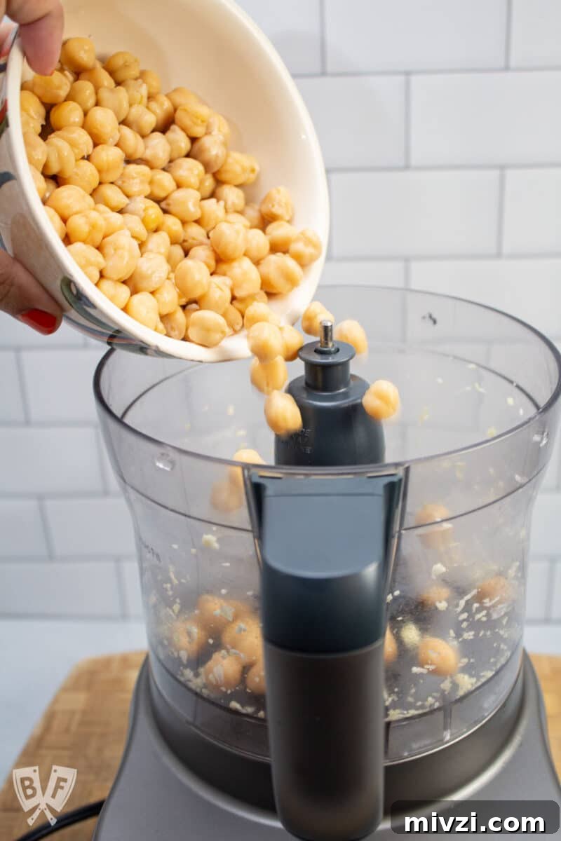 Classic Hummus from Canned Chickpeas – Quick Authentic Recipe 9 Adding chickpeas to a food processor.