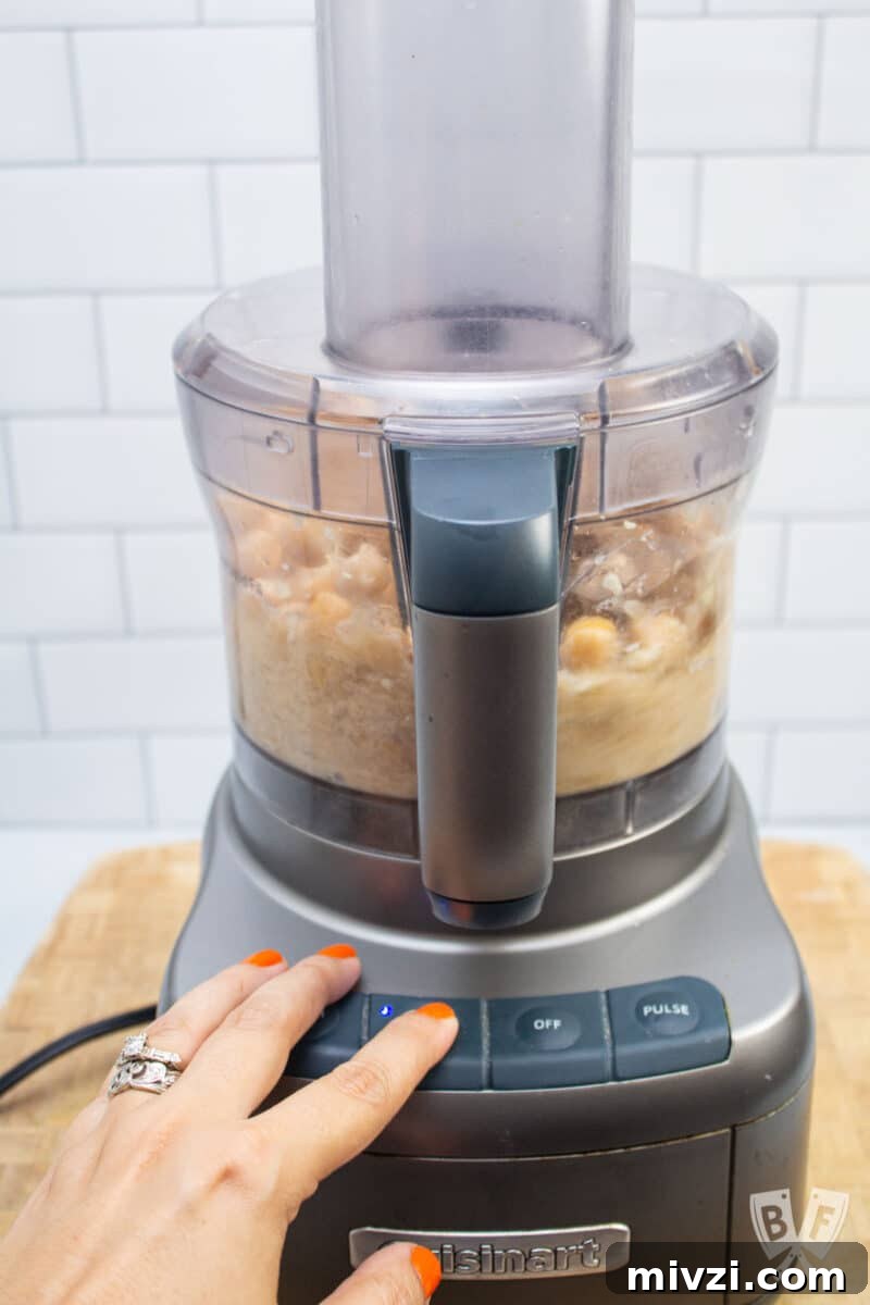 Classic Hummus from Canned Chickpeas – Quick Authentic Recipe 11 Combining ingredients for hummus in a food processor.