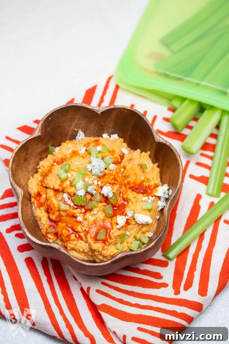 Classic Hummus from Canned Chickpeas – Quick Authentic Recipe 20 Overhead view of a bowl of buffalo chickpea hummus with celery sticks and blue cheese.