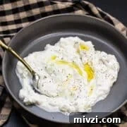 Classic Hummus from Canned Chickpeas – Quick Authentic Recipe 27 Bowl of tzatziki with olive oil drizzled over the top.