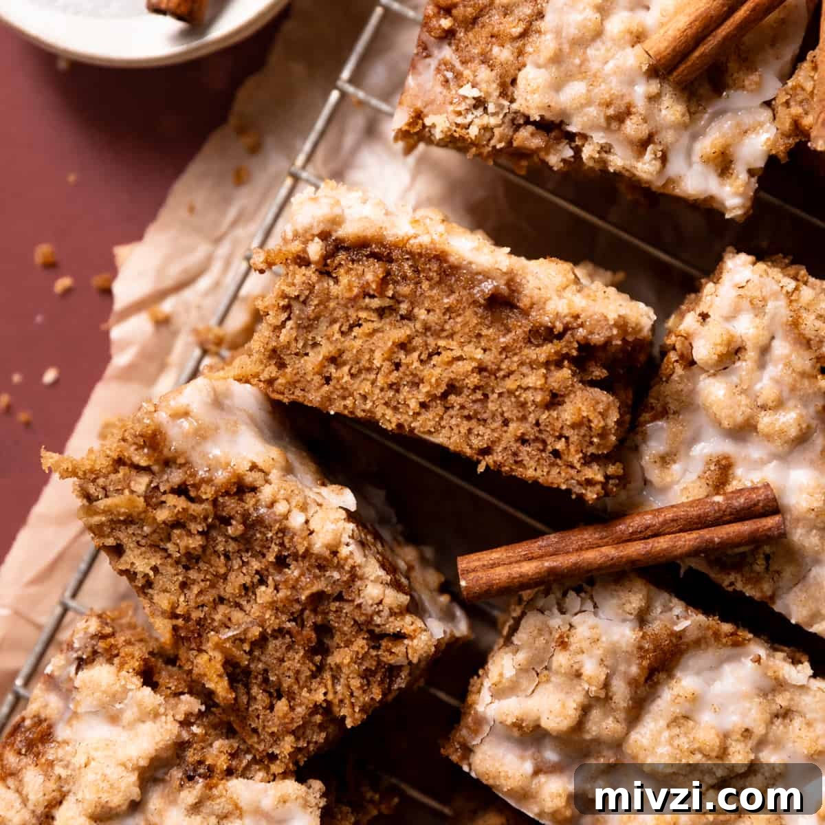 Slices of apple cake on a wire rack with vanilla glaze drizzled on top.