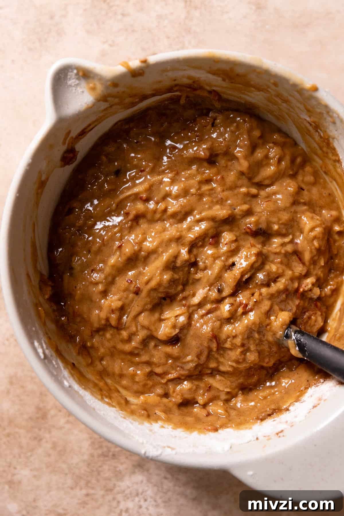 The apple cake batter in a mixing bowl after folding in the dry ingredients.