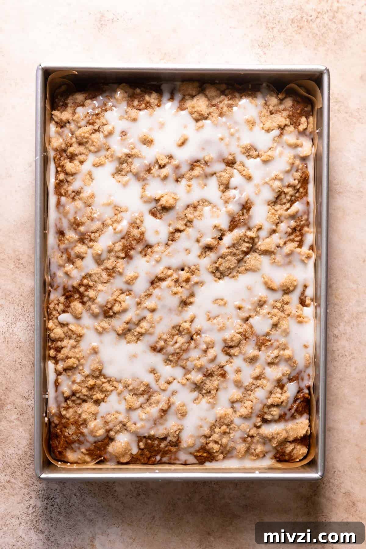 Apple cinnamon cake with vanilla glaze poured over the top.