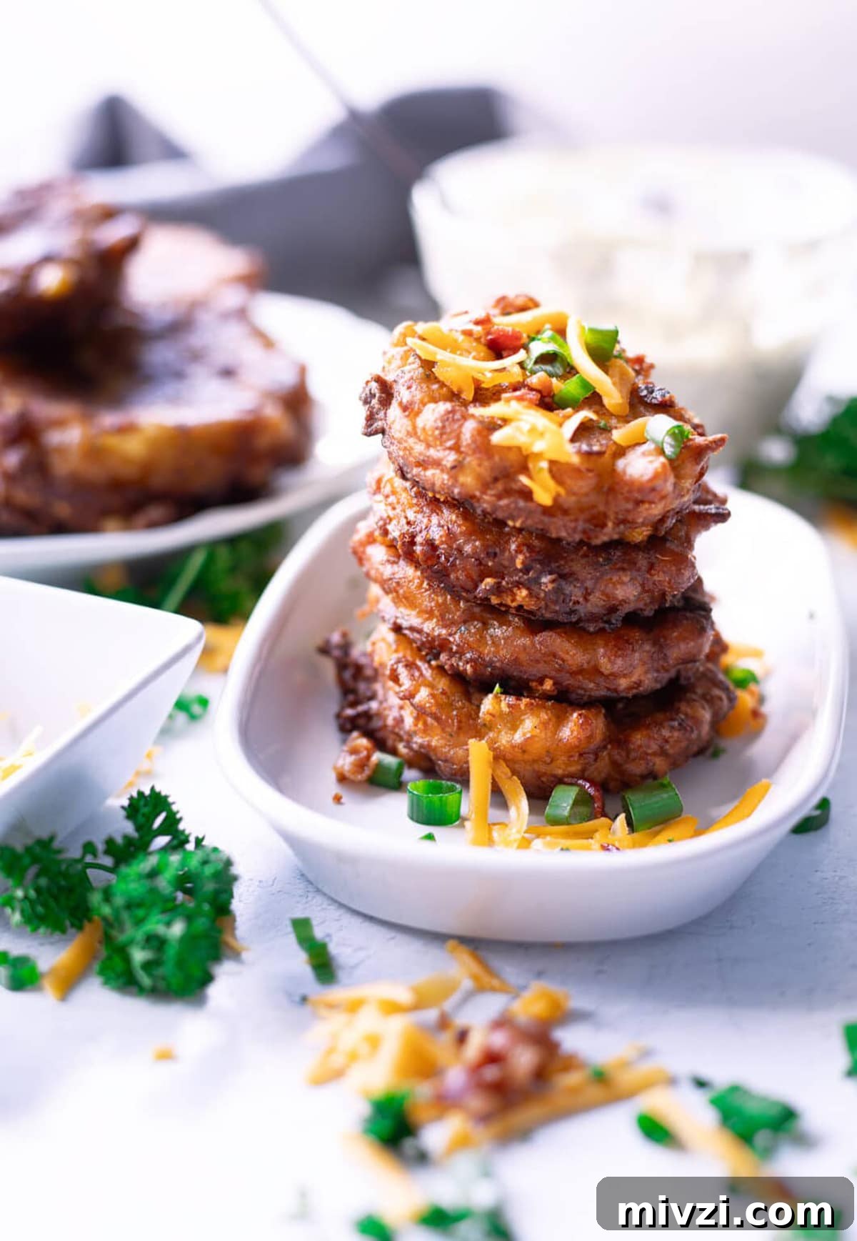Stacked corn fritters in a white dish.
