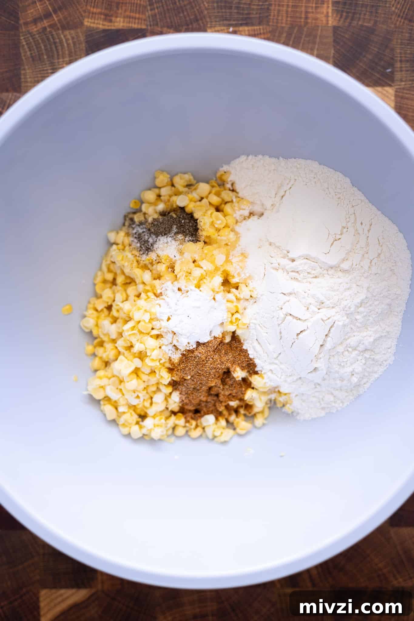 Ingredients to make corn fritters in a bowl.