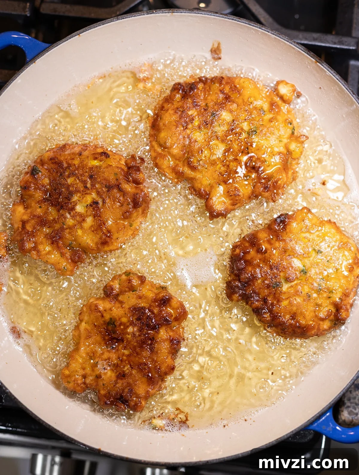 Corn Fritters deep frying in a pan.