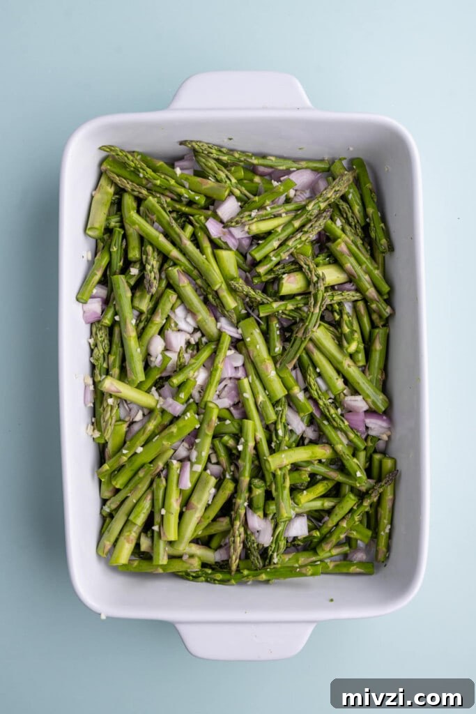 Cheesy Baked Asparagus Casserole Recipe with Crispy Top 12 Mixing asparagus, shallots, and garlic in a casserole dish
