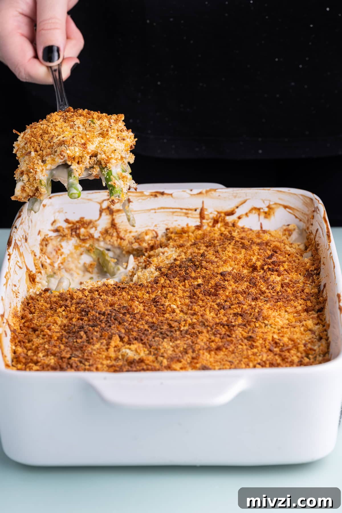 Cheesy Baked Asparagus Casserole Recipe with Crispy Top 17 Using a large spoon to scoop out a serving of Asparagus Casserole