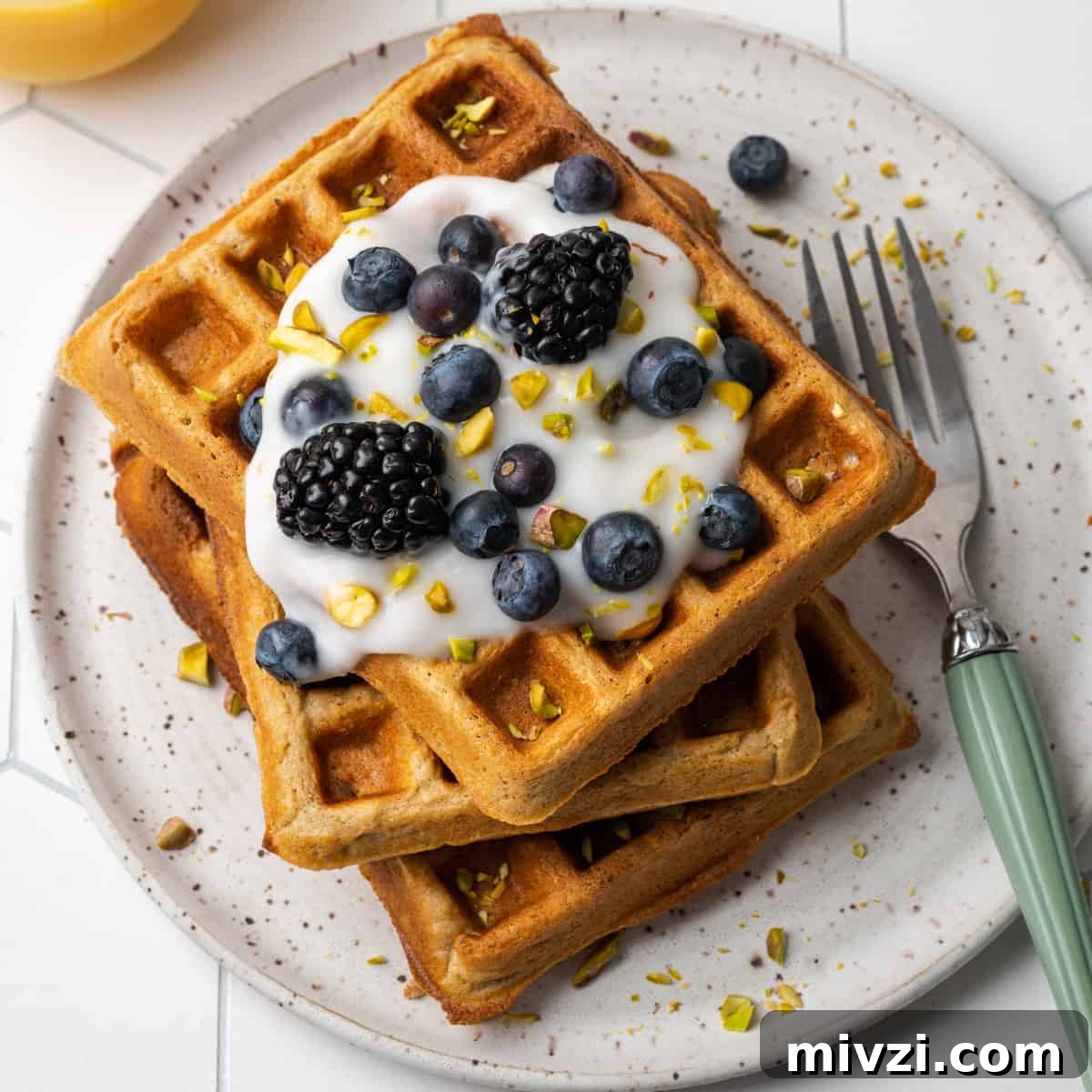 A stack of gluten free oat flour waffles on a white plate.