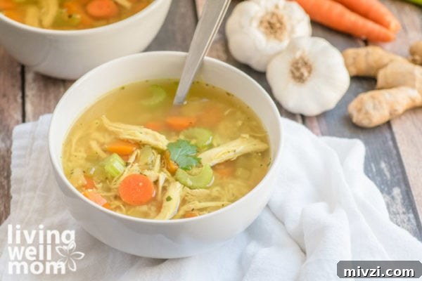 Yummy paleo chicken soup in a white bowl with chunks of chicken and vegetables
