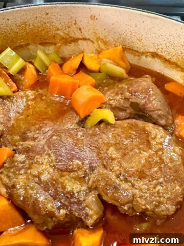 A Dutch oven of tender pot roast with vegetables.