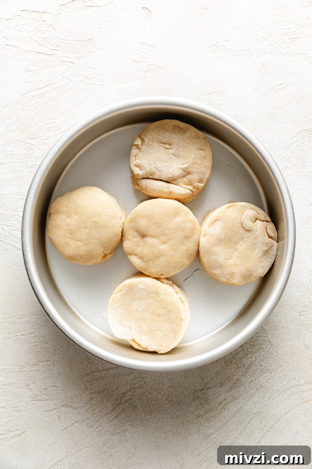 How to Make Perfectly Flaky Homemade Biscuits 7 Unbaked biscuit dough in a pan.