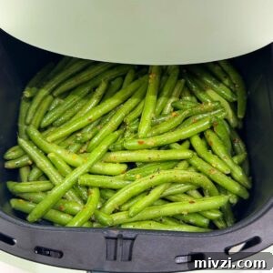 Crispy Air Fryer Green Beans with Garlic and Parmesan 6 Green beans in an air fryer before cooking.