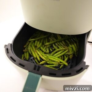 Crispy Air Fryer Green Beans with Garlic and Parmesan 7 Green beans in an air fryer.