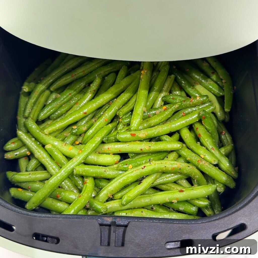 Crispy Air Fryer Green Beans with Garlic and Parmesan 9 Green beans in an air fryer before cooking.