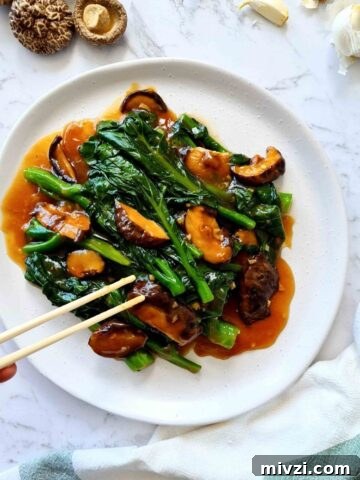 Plate of Chinese broccoli with mushrooms and sauce