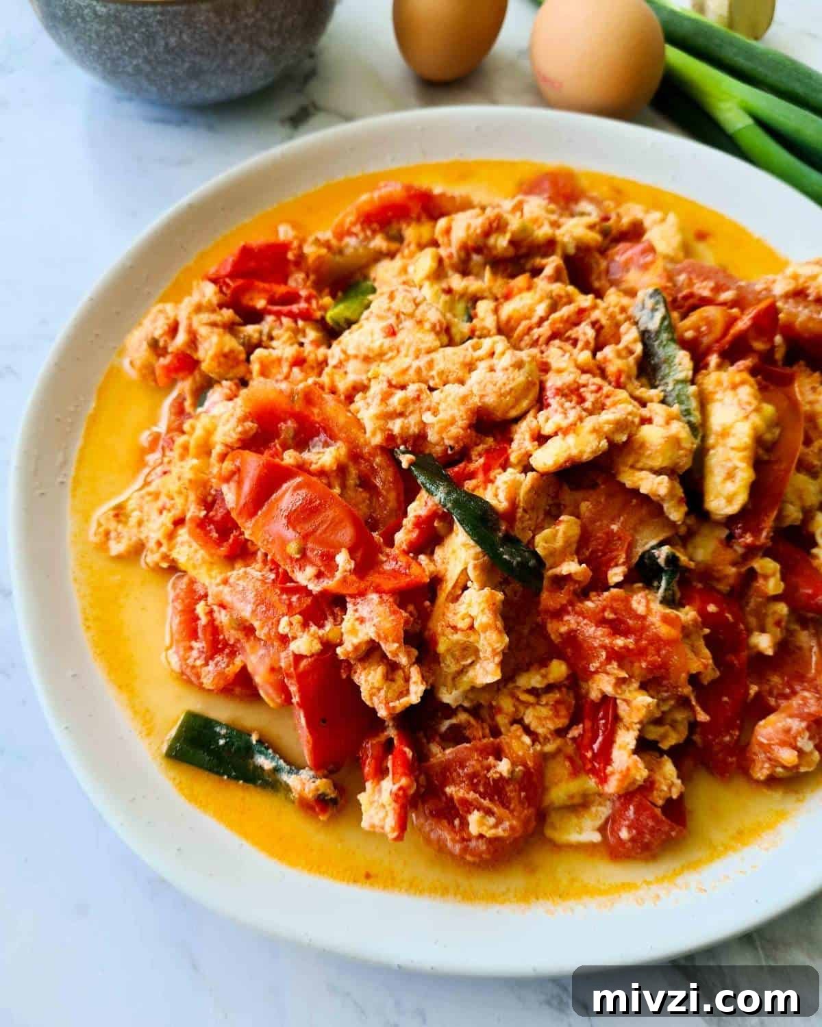 A large plate of tomato and eggs from the side