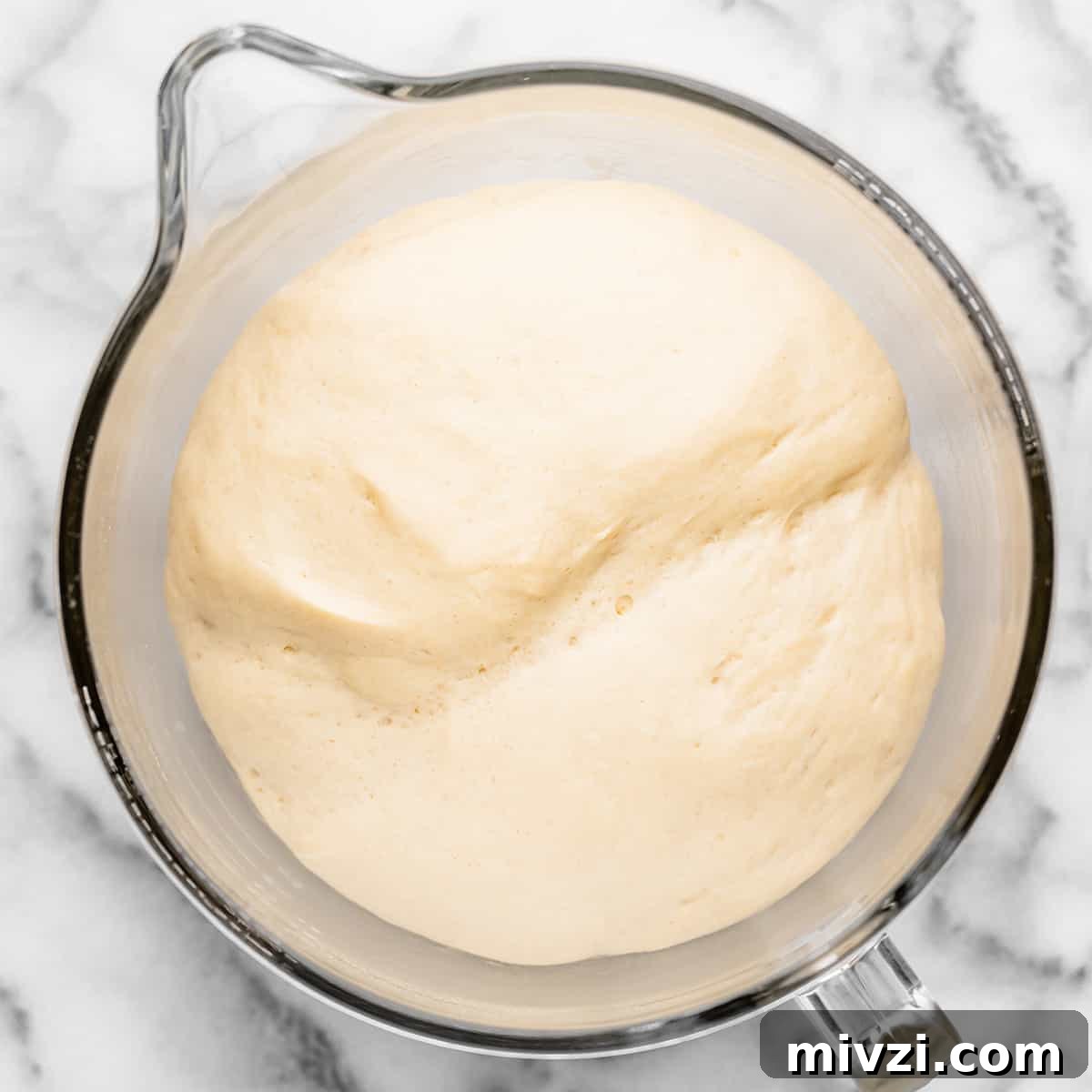 Crispy Homemade Breadsticks Recipe for Perfect Dinner Sides 9 two photos showing How to Make Breadsticks - dough after rising in a glass mixing bowl