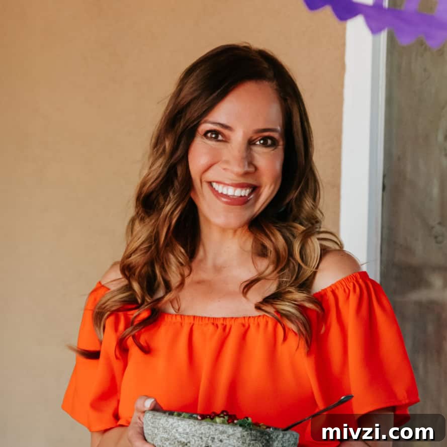 Garlic Shrimp Mexican-Style: Mojo de Ajo Camarones Recipe 3 Yvette Marquez muy bueno Mexican food blogger in an orange dress holding a molcajete.