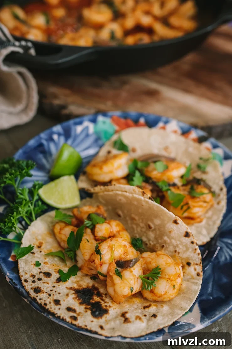 Garlic Shrimp Mexican-Style: Mojo de Ajo Camarones Recipe 8 a plate with two tacos filled with Mexican-Style Garlic Shrimp.