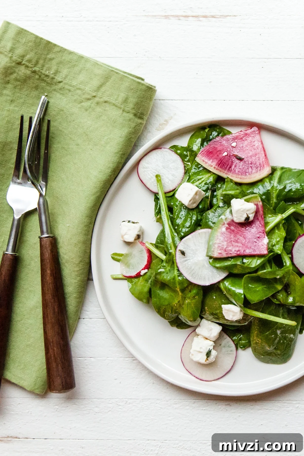 Watermelon Radish: Taste, Uses, and How to Cook It 4 White plate of spinach and radish salad with feta.
