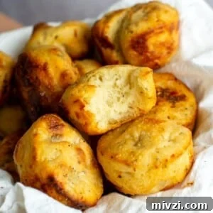 Sourdough focaccia rolls in a bowl with a bite taken out of one of them.