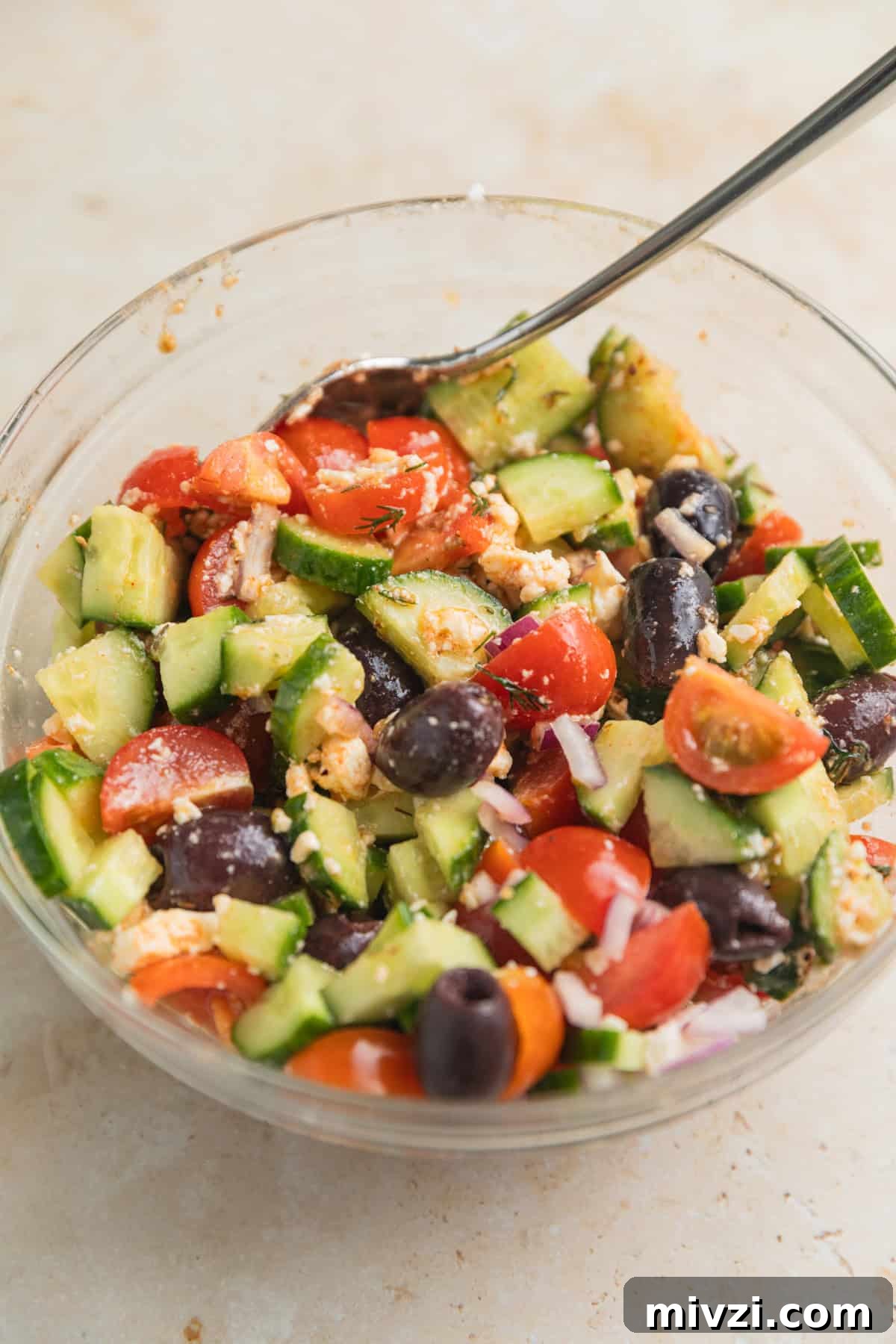 Mediterranean-Style Grilled Chicken with Lemon and Herbs 7 Cucumber feta salad in glass bowl with spoon.