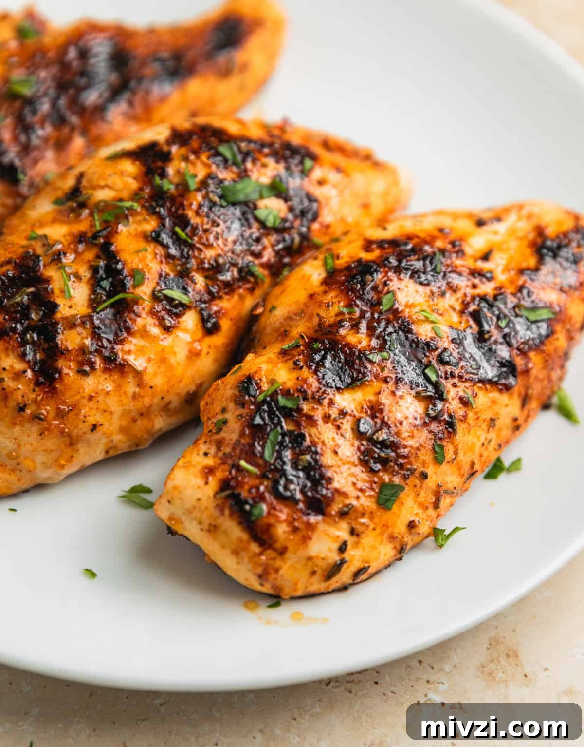 Mediterranean-Style Grilled Chicken with Lemon and Herbs 9 White plate with grilled mediterranean chicken resting.