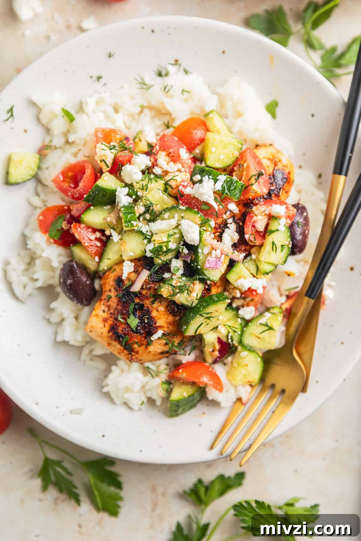 Mediterranean-Style Grilled Chicken with Lemon and Herbs 10 Grilled chicken on plate over rice topped with cucumbers, feta, olives and dill.