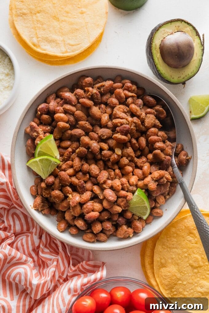 Pinto Bean Tostadas with Fresh Tomato and Corn Salsa 5 Refried, seasoned pinto beans in a bowl garnished with thinly-sliced lime.