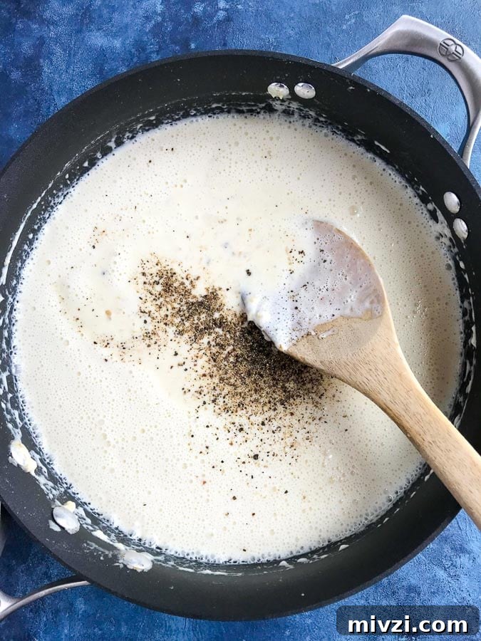 Creamy Chicken Alfredo Pasta Recipe: Quick Garlic Parmesan Dinner 3 stirring creamy alfredo sauce