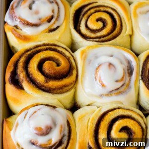 Homemade cinnamon rolls, some with frosting on top.