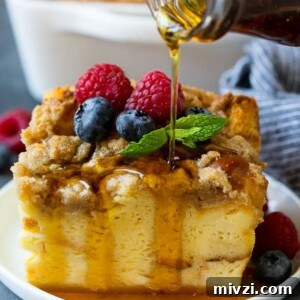 A piece of french toast casserole with syrup being poured over the top.